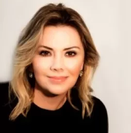 Retrato de mulher loira sorrindo, com blusa preta.