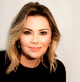 Retrato de mulher loira sorrindo, com blusa preta.