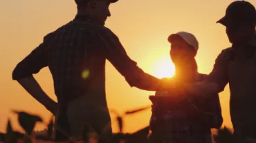 3 Profissionais de Startup do Agronegócio Conversando no Campo