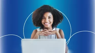 Mulher sorridente usando laptop com fundo azul.