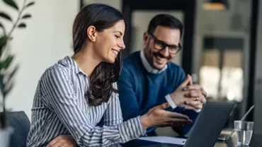 Trabalho colaborativo com computador portátil em ambiente de escritório moderno