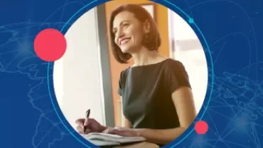 Mulher sorrindo enquanto escreve em um caderno.