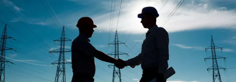 Silhueta de dois homens apertando as mãos em um campo de energia elétrica