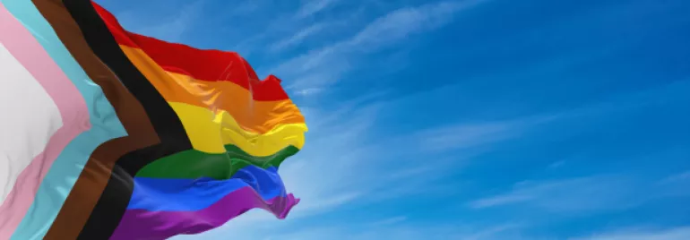 Bandeira LGBTQIAP voando no céu azul 