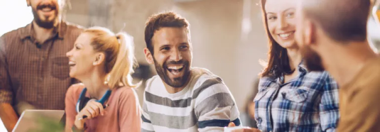 Homem sorrindo enquanto trabalho com o resto do time