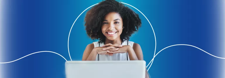 Mulher sorridente diante de um laptop com fundo azul.