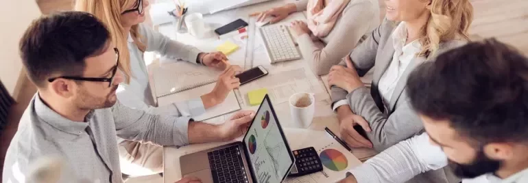 Pessoas discutindo gráficos em uma reunião de trabalho.