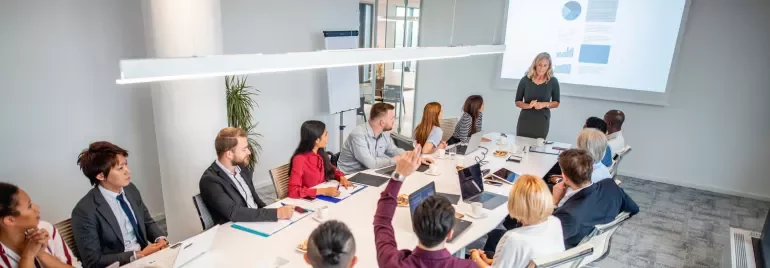 Homens e mulheres em uma sala de reunião sentados e conversando