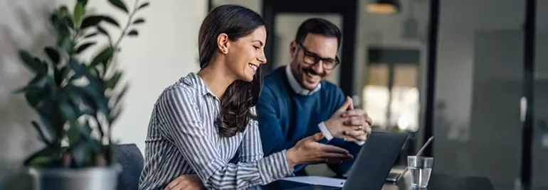 Trabalho colaborativo com computador portátil em ambiente de escritório moderno