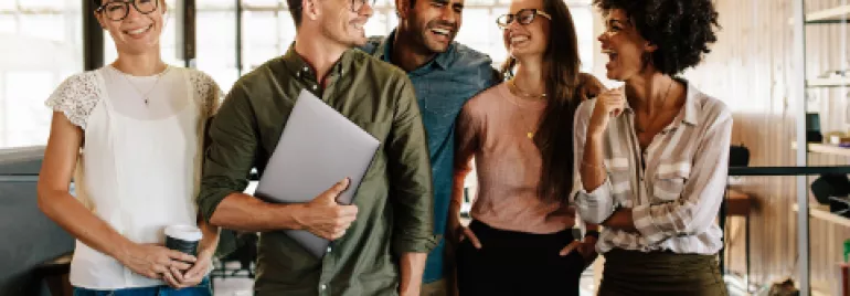 Grupo de colegas sorrindo em um escritório.