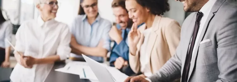 Equipe diversa discutindo sobre computador no escritório.