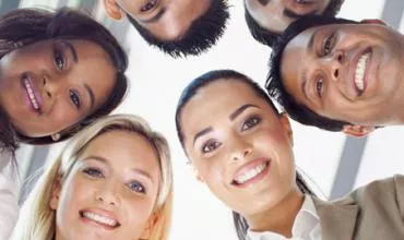 Grupo de pessoas de várias etnias sorrindo para a câmera.