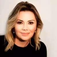 Retrato de mulher loira sorrindo, com blusa preta.
