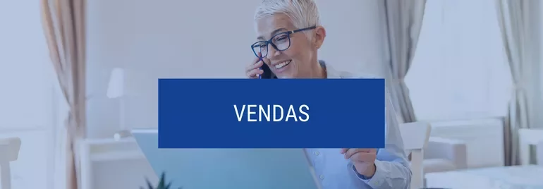 Pessoa sorrindo ao telefone com texto 'Vendas' sobreposto.