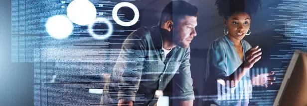 Duas pessoas discutindo código em uma tela de computador.