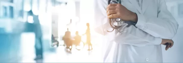 Médico segurando estetoscópio em hospital.