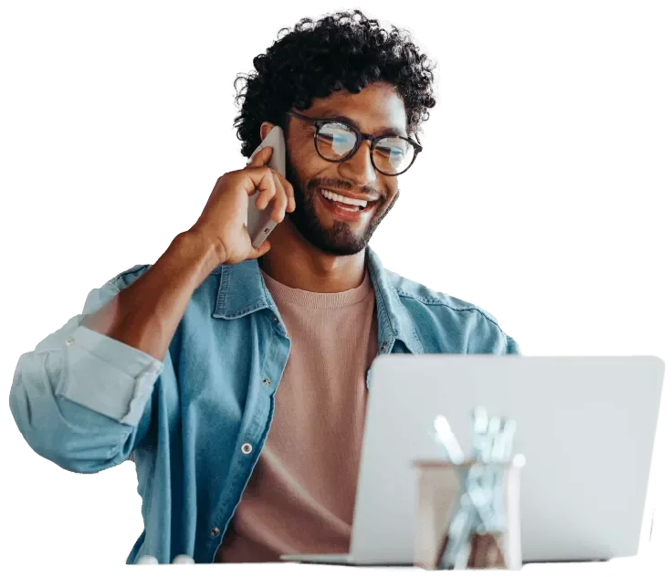 Profissional trabalhando em notebook e atendendo uma chamada telefônica.