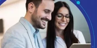 Dois colegas sorrindo e olhando para um tablet.