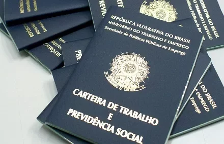 Carteiras de Trabalho e Previdência Social em uma mesa.