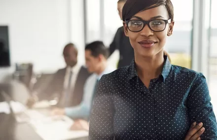 Mulher sorridente com óculos em uma reunião de negócios.